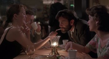 Movie still from “The Hand That Rocks the Cradle” (1992), directed by Curtis Hanson – A group of people sitting at a table drinking and smoking; Medium shot, Over the shoulder angle