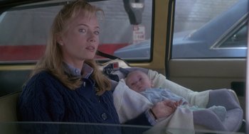 Movie still from “The Hand That Rocks the Cradle” (1992), directed by Curtis Hanson – A woman sitting in a car with a baby in her lap; Close Up shot, Over the shoulder angle
