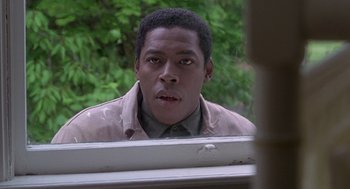 Movie still from “The Hand That Rocks the Cradle” (1992), directed by Curtis Hanson – A man looking into a mirror while standing in front of a window; Close Up shot, Over the shoulder angle