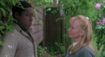 Movie still from “The Hand That Rocks the Cradle” (1992), directed by Curtis Hanson – A man and a woman standing next to each other; Close Up shot, Over the shoulder angle