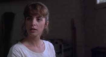 Movie still from “The Hand That Rocks the Cradle” (1992), directed by Curtis Hanson – A woman in a white shirt is standing in a room; Close Up shot, Over the shoulder angle