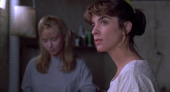 Movie still from “The Hand That Rocks the Cradle” (1992), directed by Curtis Hanson – Two women sitting in front of each other in a room; Close Up shot, Low angle