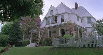 Movie still from “The Hand That Rocks the Cradle” (1992), directed by Curtis Hanson – A man on a ladder painting a house's roof; Extreme Wide shot, Low angle
