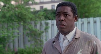 Movie still from “The Hand That Rocks the Cradle” (1992), directed by Curtis Hanson – A man in a white shirt and a brown jacket looking to his left; Close Up shot, Low angle