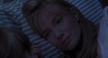 Movie still from “The Hand That Rocks the Cradle” (1992), directed by Curtis Hanson – A woman laying in a bed looking at the camera; Close Up shot, Over the shoulder angle