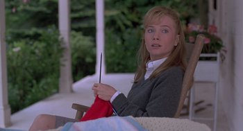 Movie still from “The Hand That Rocks the Cradle” (1992), directed by Curtis Hanson – A woman sitting in a chair holding a red cloth; Close Up shot, High angle