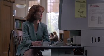 Movie still from “The Hand That Rocks the Cradle” (1992), directed by Curtis Hanson – A woman sitting in front of a computer monitor; Medium shot, Low angle