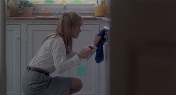 Movie still from “The Hand That Rocks the Cradle” (1992), directed by Curtis Hanson – A woman is cleaning a kitchen with a spray bottle and a cloth; Medium shot, Low angle
