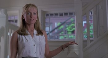 Movie still from “The Hand That Rocks the Cradle” (1992), directed by Curtis Hanson – A woman in a white shirt is standing in front of a window; Medium shot, Low angle