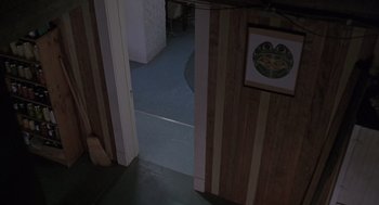 A doorway leading to a dining room with a picture hanging on the wall