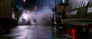 Movie still from “The Hard Way” (1991), directed by John Badham – A truck is driving down the street at night; Wide shot, Low angle