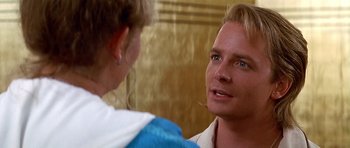 Movie still from “The Hard Way” (1991), directed by John Badham – A man with blonde hair and blue eyes talking to a woman; Close Up shot, Over the shoulder angle