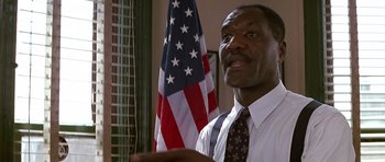 Movie still from “The Hard Way” (1991), directed by John Badham – A man in a white dress shirt and a red and white striped tie; Close Up shot, Low angle