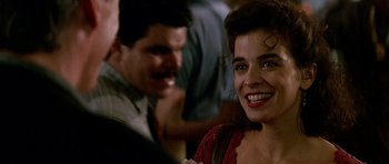 Movie still from “The Hard Way” (1991), directed by John Badham – A woman smiles at the camera in front of a man; Close Up shot, Over the shoulder angle