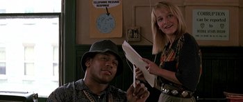 Movie still from “The Hard Way” (1991), directed by John Badham – A man and a woman holding papers in a room; Medium shot, Low angle