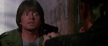 Movie still from “The Hard Way” (1991), directed by John Badham – A man holding a gun up to his face; Close Up shot, Low angle