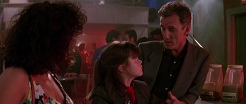 Movie still from “The Hard Way” (1991), directed by John Badham – A man and a woman talking to each other in front of a crowd; Close Up shot, Over the shoulder angle