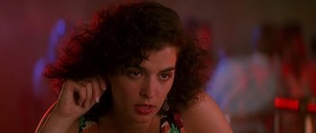 Movie still from “The Hard Way” (1991), directed by John Badham – A person with curly black hair; Close Up shot, Over the shoulder angle