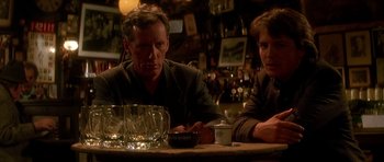 Movie still from “The Hard Way” (1991), directed by John Badham – A man and a woman sitting at a table in a bar; Medium shot, Low angle