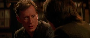 Movie still from “The Hard Way” (1991), directed by John Badham – A man sitting in front of another man in front of a table; Close Up shot, Over the shoulder angle