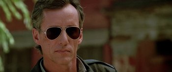 Movie still from “The Hard Way” (1991), directed by John Badham – A person wearing sunglasses; Close Up shot, Low angle