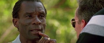 Movie still from “The Hard Way” (1991), directed by John Badham – A person wearing a ring and sunglasses; Close Up shot, Low angle