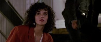 Movie still from “The Hard Way” (1991), directed by John Badham – A person with curly hair wearing a red jacket; Close Up shot, Over the shoulder angle