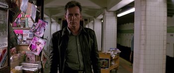 Movie still from “The Hard Way” (1991), directed by John Badham – A man standing in a room with boxes in front of him; Medium shot, Low angle