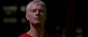 Movie still from “The Hard Way” (1991), directed by John Badham – A person wearing a red shirt; Close Up shot, Low angle