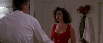 Movie still from “The Hard Way” (1991), directed by John Badham – A woman in a red dress talking to a man in a white shirt; Medium shot, Over the shoulder angle