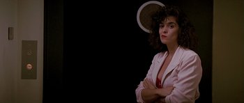 Movie still from “The Hard Way” (1991), directed by John Badham – A woman in a white jacket is posing for a picture; Close Up shot, Low angle