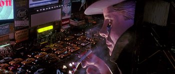 Movie still from “The Hard Way” (1991), directed by John Badham – A man holding a cell phone while standing in front of cars; Extreme Close Up shot, Low angle