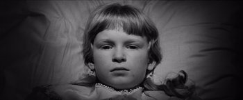 Movie still from “The Haunting” (1963), directed by Robert Wise – A young girl is laying in a bed; Close Up shot, High angle