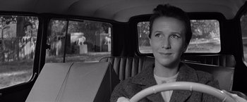 Movie still from “The Haunting” (1963), directed by Robert Wise – A black and white photo of a woman driving a car; Close Up shot, Over the shoulder angle