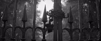 Movie still from “The Haunting” (1963), directed by Robert Wise – A black - and - white photo of a gate with a chain on it; Wide shot, Low angle