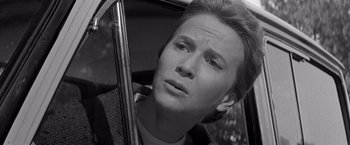 Movie still from “The Haunting” (1963), directed by Robert Wise – A man sitting in the passenger seat of a car looking out the window; Close Up shot, High angle