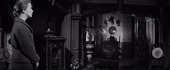 Movie still from “The Haunting” (1963), directed by Robert Wise – A black and white photo of a living room; Wide shot, High angle