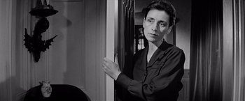 Movie still from “The Haunting” (1963), directed by Robert Wise – Black and white photograph of a woman leaning against a door; Close Up shot, High angle
