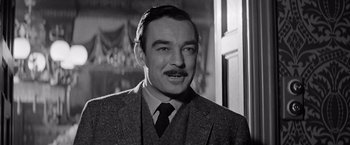 Movie still from “The Haunting” (1963), directed by Robert Wise – An old black and white photo of a man in a suit and tie; Close Up shot, Low angle