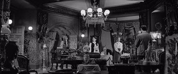 Movie still from “The Haunting” (1963), directed by Robert Wise – Two people standing in a room with a chandelier; Wide shot, Low angle