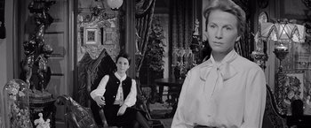 Movie still from “The Haunting” (1963), directed by Robert Wise – Two women sitting in chairs in an old fashioned living room; Medium shot, Low angle