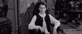 Movie still from “The Haunting” (1963), directed by Robert Wise – A black and white photo of a woman in a vest; Medium shot, High angle