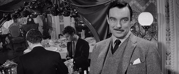 Movie still from “The Haunting” (1963), directed by Robert Wise – Black and white photograph of men in suits and ties; Close Up shot, Over the shoulder angle