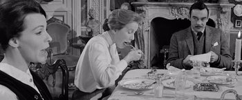 Movie still from “The Haunting” (1963), directed by Robert Wise – A woman is sitting at a table eating food; Medium shot, Over the shoulder angle