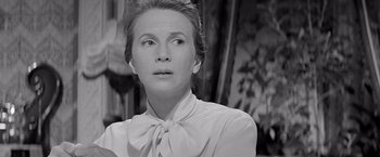 Movie still from “The Haunting” (1963), directed by Robert Wise – An older woman wearing a white shirt and a bow tie; Close Up shot, Over the shoulder angle