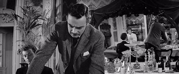 Movie still from “The Haunting” (1963), directed by Robert Wise – A black and white photo of a man in a suit and tie; Medium shot, Low angle