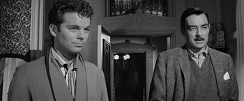 Movie still from “The Haunting” (1963), directed by Robert Wise – A man and a woman standing next to each other in front of a doorway; Close Up shot, Over the shoulder angle