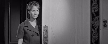 Movie still from “The Haunting” (1963), directed by Robert Wise – A black and white photo of a woman standing in a doorway; Close Up shot, Over the shoulder angle
