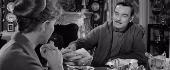 Movie still from “The Haunting” (1963), directed by Robert Wise – An old photo of a man and a woman sitting at a dinner table; Medium shot, Over the shoulder angle