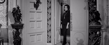 Movie still from “The Haunting” (1963), directed by Robert Wise – A woman standing at the door of a house; Medium shot, High angle
